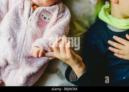 Deux enfants, un bébé et un bébé se serrer la main. Banque D'Images