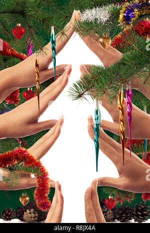 La forme de l'arbre de noël faites par les enfants les mains sur fond blanc et encadré de branches d'arbre de Noël décoré et ornements colorés Banque D'Images