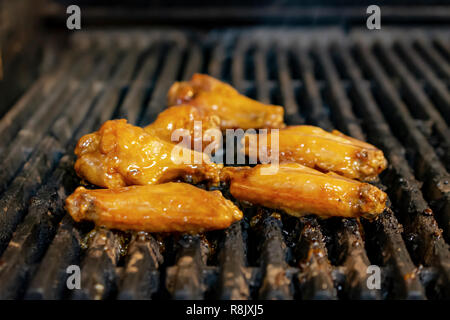 Ailes de poulet Sauced close up on restaurant grill. Banque D'Images