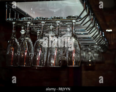 Nettoyer et laver les verres polis qui pèsent sur un bar rack. Banque D'Images