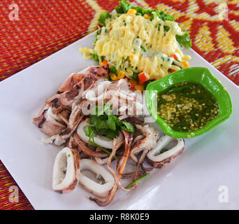 Calmar grillé / delicious Calmar grillé tranche sur plaque blanche et mélanger la crème de légumes salade de fruits de mer avec sauce chili - traditionnel du calmar grillé s Banque D'Images