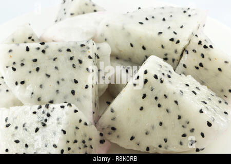 Dragon fruit sucré frais / close up tropical fruit du dragon blanc haché pièce tranche sur fond blanc plaque selective focus Banque D'Images