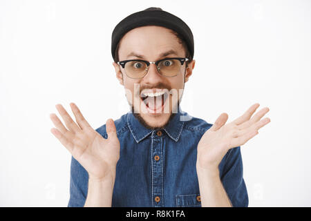 Friendly enthousiaste homme aime les surprises. Portrait de charmed ravis bon gars barbu à élever palms criait dans la joie et le bonheur l'étonnement intrigué tout en regardant une grande nouvelle audience Banque D'Images