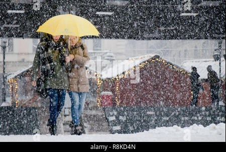 Belgrade, Serbie - 15 décembre 2018 : Deux jeunes femmes marcher sous parapluie dans les fortes chutes de neige dans la rue de la ville avec des stands de Noël décoré dans il ba Banque D'Images