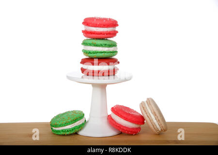 Style de vacances de Noël Biscuits macaron empilés sur un piédestal et la pose sur la table en bois isolé sur blanc. Design minimaliste. Banque D'Images