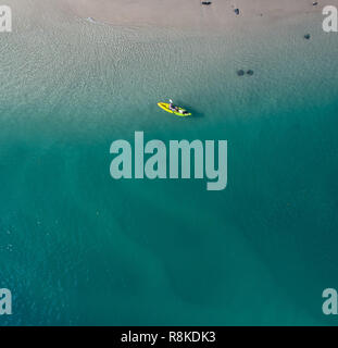 Kayak homme dans un océan bleu près d'une plage tropicale parfait pour fitness, fun, la pêche et les vacances. Vue aérienne au lever du soleil. Banque D'Images