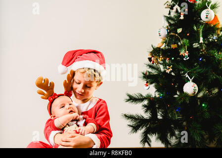 Enfant et bébé nouveau-né, les frères et sœurs déguisées en concept de vacances de Noël, Banque D'Images