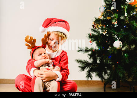 Enfant et bébé nouveau-né, les frères et sœurs déguisées en concept de vacances de Noël, Banque D'Images