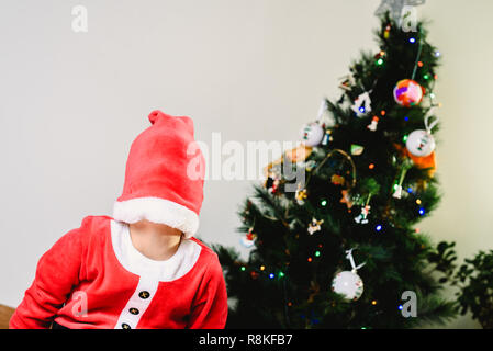 Tout-petit garçon timide colmaté avec visage, expressions et concepts de noël. Banque D'Images