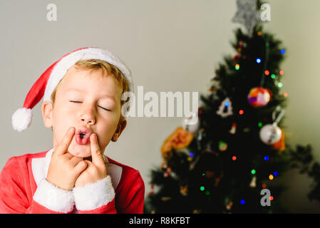 Tout-petit et le Père Noël costume making faces suivant pour arbre de noël, fêtes de Noël concept. Banque D'Images