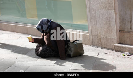 Vieux gypsy vous demande l'aumône assis sur une rue Banque D'Images