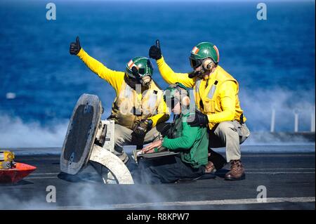 Les directeurs de vol connu comme chemises jaunes, un signal F/A-18 Super Hornet pour lancer à bord du poste de pilotage de la classe Nimitz porte-avions USS Harry S. Truman le 7 décembre 2018 dans l'océan Atlantique. Chemises jaunes sont portés par les gestionnaires d'aéronefs Aéronefs, administrateurs, officiers et catapulte Agents Arrêt considéré comme le plus difficile et important travail sur le poste de pilotage. Banque D'Images