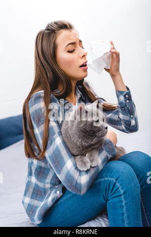 Fille avec des mouchoirs et des allergies holding cat British shorthair Banque D'Images