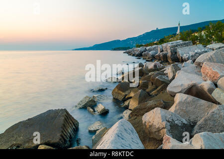 Coucher du soleil à la plage ci-dessous le phare de Trieste, Frioul-Vénétie Julienne, Italie Banque D'Images