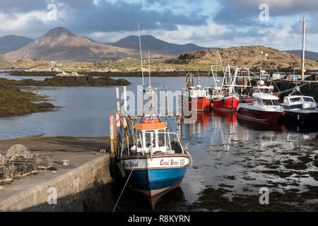 L'Irlande, dans le comté de Galway, Ballynakill, Connemara, des bateaux en bois et les bateaux de pêche dans le port, les montagnes Twelve Bens et Tully montagnes en arrière-plan Banque D'Images