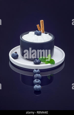 Les bleuets et Quark garnie avec des bâtons de cannelle et de menthe fraîche Banque D'Images