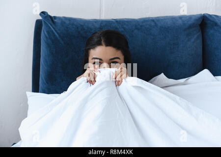 Belle mixed race girl looking out de contrat cadre dans la matinée dans la chambre Banque D'Images