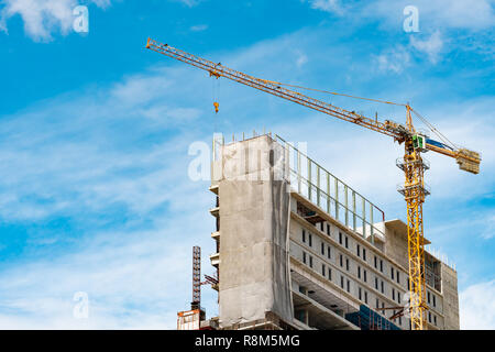 Site de construction avec grue et bâtiment. Secteur de l'immobilier. L'utilisation de grues de levage du rabatteur de l'équipement dans la construction du site. La construction en acier et con Banque D'Images