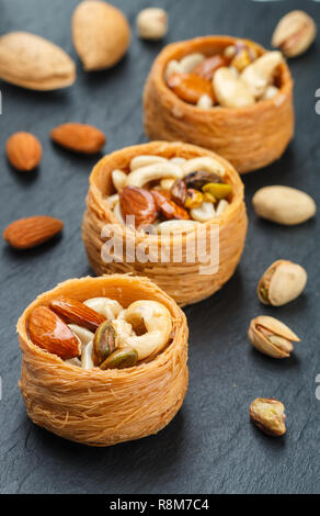 Bonbons traditionnels 'nid d'oiseau' dans le sirop de miel avec écrou remplissage - Amandes, Noix de cajou, pistaches. Baklava close-up. Un délicieux dessert. S Banque D'Images