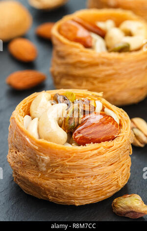 Bonbons traditionnels 'nid d'oiseau' dans le sirop de miel avec écrou remplissage - Amandes, Noix de cajou, pistaches. Baklava close-up. Un délicieux dessert. S Banque D'Images