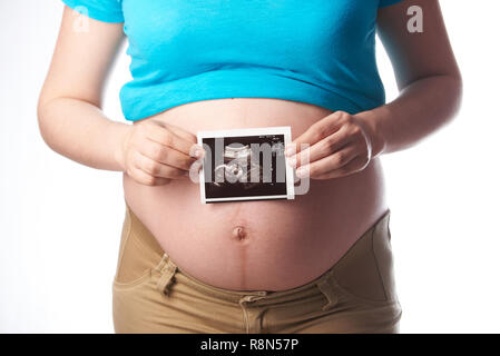 Femme enceinte tenir échographie isolé sur fond blanc Banque D'Images