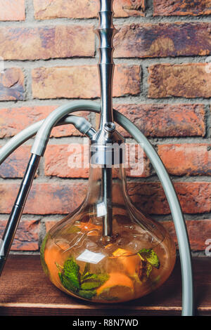 Shisha avec bol de fruits avec de la fumée colorée en Bar narguilé libre. Banque D'Images