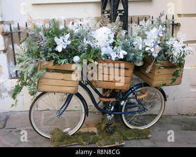 Un vélo décoré pour Noël, orné de trois caisses de fleurs et feuillages de fête, est stationné sur une rue dans le centre-ville de York ; Décembre 2018 Banque D'Images