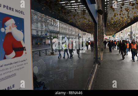 Décembre 08, 2018 - Paris, France : Gilet jaune protestataires se reflètent dans les vitres de la boutique de luxe des Galeries Lafayette comme ils se dirigent vers l'avenue des Champs-Élysées. Manifestation des gilets jaunes du 8 decembre a Paris, l'acte IV de leur mobilisation. *** FRANCE / PAS DE VENTES DE MÉDIAS FRANÇAIS *** Banque D'Images