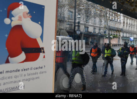 Décembre 08, 2018 - Paris, France : Gilet jaune protestataires se reflètent dans les vitres de la boutique de luxe des Galeries Lafayette comme ils se dirigent vers l'avenue des Champs-Élysées. Manifestation des gilets jaunes du 8 decembre a Paris, l'acte IV de leur mobilisation. *** FRANCE / PAS DE VENTES DE MÉDIAS FRANÇAIS *** Banque D'Images