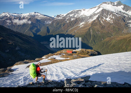 Randonneur dans la neige au-dessus de la crête Français Hut, Mt aspirant National Park, New Zealand Banque D'Images