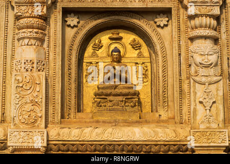 Piliers richement sculptés et Bouddha idol (lumières) sur le mur du temple de la Mahabodhi, Bodhgaya, Bihar, Inde Banque D'Images