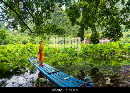 Girl standing on en radeau de bambou en fleur de lotus lake Banque D'Images