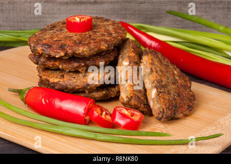 Escalopes de foie ou des crêpes avec le piment et les oignons verts sur un fond de bois Banque D'Images