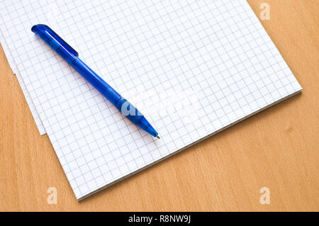 Le bloc-notes papier et stylo à bille sur la table en bois. Banque D'Images