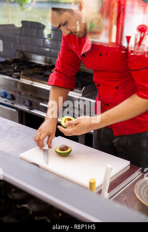 Chef de la préparation pour l'avocat salade délicieux dans une cuisine de restaurant Banque D'Images