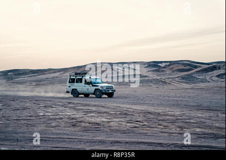 Hurghada, Egypte - Février 26, 2017 : voiture dans le désert. 4x4 Toyota Land cruiser la conduite dans les dunes de sable blanc sur fond de ciel. Safari tour. L'activité extrême. Les vacances et les voyages. Wanderlust Banque D'Images