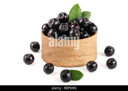 Aronie à feuilles avec bol en bois isolé sur fond blanc. Aronia noir berries Banque D'Images