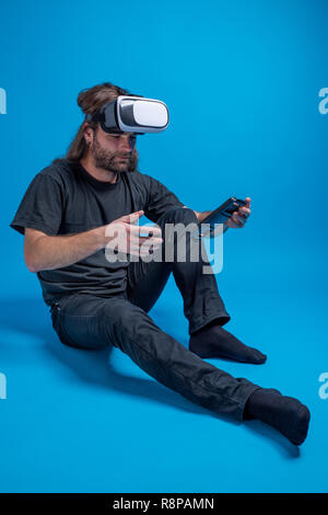 Portrait de l'homme essayant de configurer un appareil VR. Loisirs numériques et innovation hi-tech Banque D'Images