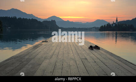 Une photo d'une jetée sur le lac de Bled en Slovénie sur un matin d'été. Collines de Nice dans l'arrière-plan. Banque D'Images
