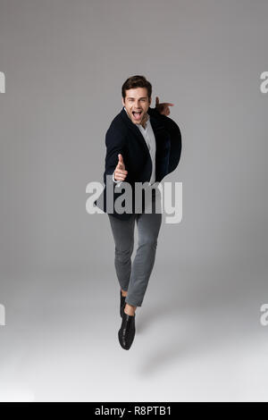 Longueur pleine image 30s en costume formel face à vous sur fond gris isolé Banque D'Images