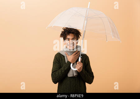 Portrait d'un jeune homme habillé en Afrique de l'écharpe et pull beige background plus isolés, en vertu de l'article parasol Banque D'Images