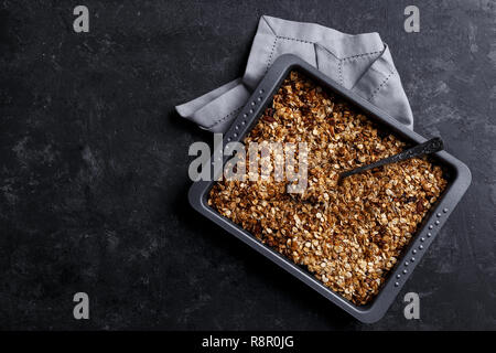 En bonne santé maison faite d'avoine granola noix et fruits sur fond noir en noir copy space Banque D'Images
