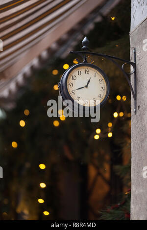 Vintage Horloge murale double face sur un fond de lumière. Maison de vacances bonne année concept de fête. Horloge murale avec chiffres arabes et un livre blanc Banque D'Images