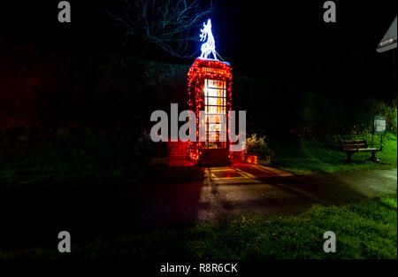 Ancien téléphone BT fort adoptée par les villageois et transformé en un livre de poche swap, décorée pour Noël. Woolaston UK Banque D'Images