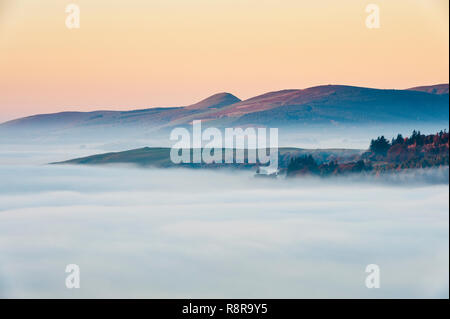 Sur la frontière galloise près de Knighton, Powys, au Royaume-Uni. Tôt le matin, vue ouest de Stonewall Hill montrant les vallées remplies d'épais brouillard Banque D'Images