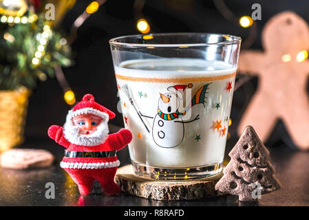 Biscuit en forme d'arbre de Noël et un verre de lait pour le Père Noël, Close up, piscine. Effets Bokeh background Banque D'Images