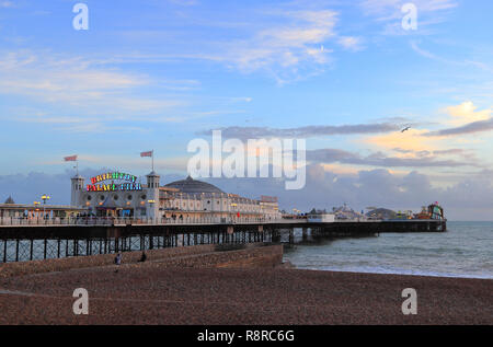 BRIGHTON, East Sussex, Angleterre, Royaume-Uni - 13 NOVEMBRE 2018 : Le Palace Pier de Brighton lumineux colorés sur la plage de Brighton au coucher du soleil. Banque D'Images