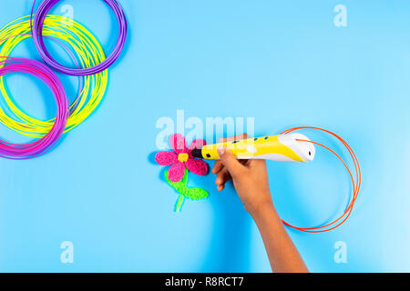 Kid part créer avec 3d stylo avec filament en plastique sur fond bleu Banque D'Images