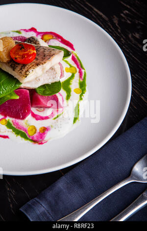 Restaurant délicieux plat de poisson blanc, brochet, loup de mer avec des légumes sous la sauce dans le fond. Exclusif sur l'alimentation saine grande plaque blanche libre Banque D'Images