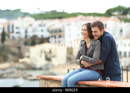 Couple heureux en amour embrassant à la côte dans une ville en vacances Banque D'Images